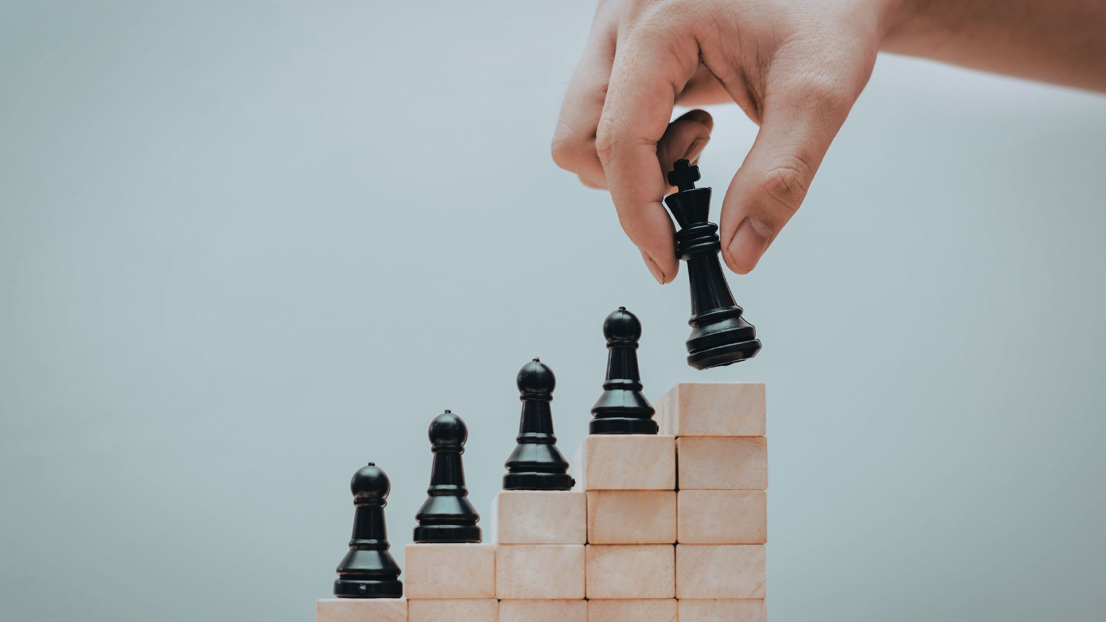 Hand moving chess piece upwards, representing the strategic advantage a gdpr audit can bring a company